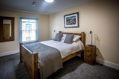 a bedroom with a large wooden bed and a window at Caernarfon Apartments in Caernarfon