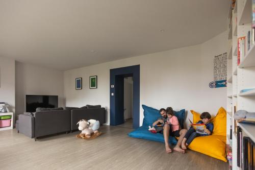 three children sitting on a couch in a living room at B&B La Maison de Julia in Albi