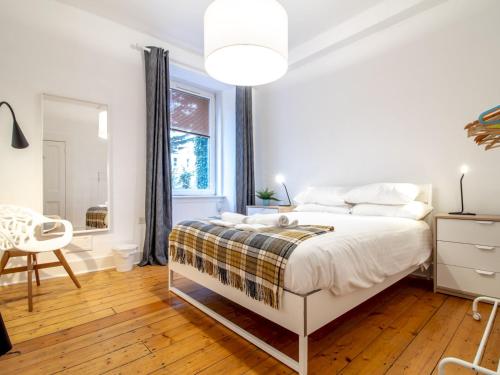 a white bedroom with a bed and a window at Stylish & Charming Retreat for 2- City Centre! in Edinburgh