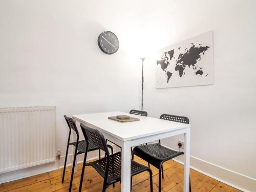 a white table with chairs and a clock on a wall at Stylish & Charming Retreat for 2- City Centre! - Pass the Keys in Edinburgh