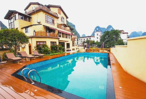 a large swimming pool in front of a building at Yangshuo Coco Garden Hotel in Yangshuo