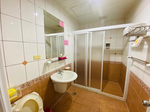 a bathroom with a shower and a toilet and a sink at Han Xiang Ju in Magong