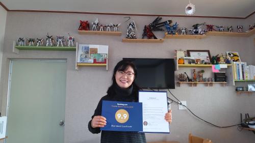 a woman holding up a sign in a room at Blue Island Guesthouse in Seogwipo