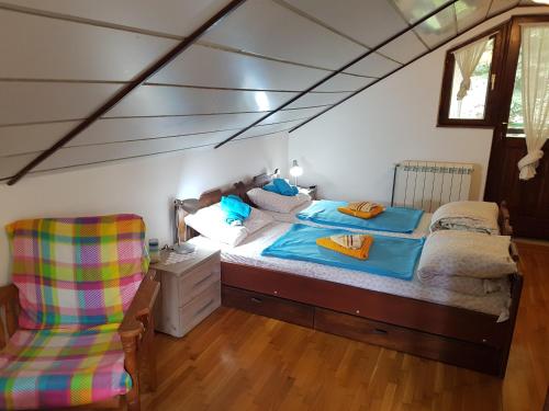 1 dormitorio con 1 cama y 1 silla en Nena & Rale Rooms, en Donji Milanovac