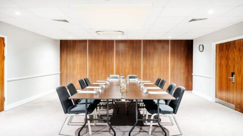 a conference room with a long table and chairs at Holiday Inn London Luton Airport by IHG in Luton