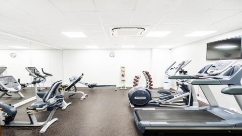 a gym with treadmills and elliptical machines at Holiday Inn London Luton Airport by IHG in Luton