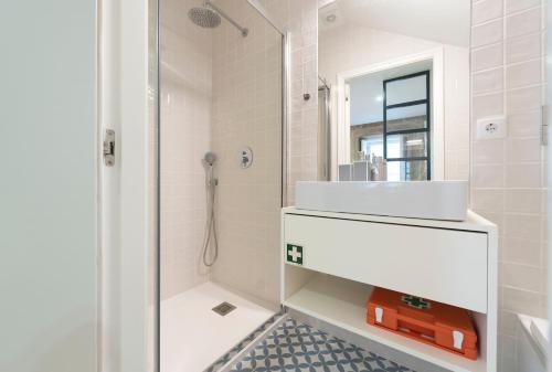 y baño blanco con lavabo y ducha. en LovelyStay - Vitoria Viewpoint 1BR Flat, en Oporto