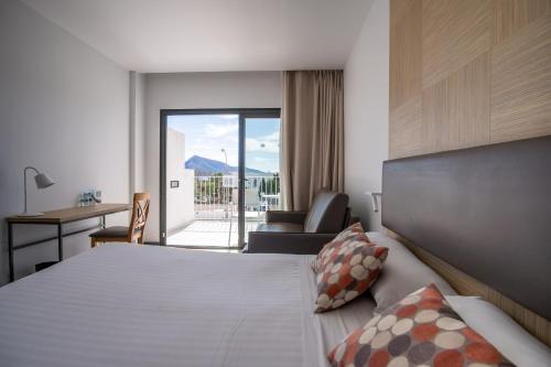Habitación de hotel con cama, escritorio y silla en Hotel Cap Negret, en Altea