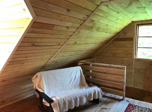 een kamer met een bed op een houten zolder bij Domek nad Rudką in Zwierzyniec