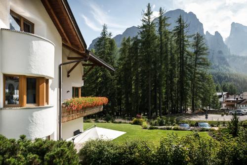 a house with a view of a garden and mountains at Residence Floralp in Colfosco