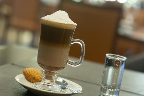 a drink in a glass mug on a table with cookies at Hotel Diego de Almagro Chillan in Chillán
