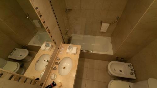 a bathroom with two sinks and a toilet and a tub at Rochester Calafate in El Calafate