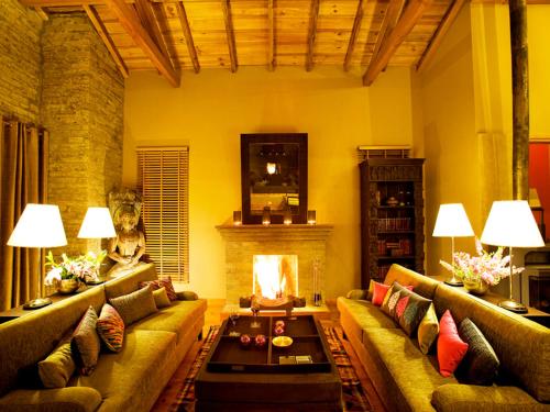 a living room with a couch and a fireplace at Mary Budden Estate in Almora