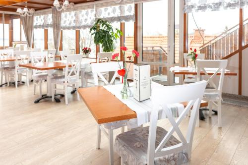 ein Restaurant mit weißen Tischen, weißen Stühlen und Fenstern in der Unterkunft Camping Marina Nowe Guty in Nowe Guty