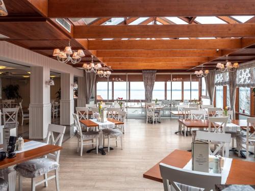 a restaurant with wooden ceilings and tables and chairs at Camping Marina Nowe Guty in Nowe Guty