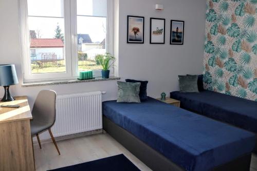 a bedroom with two beds and a desk and a window at Gościniec przy Spacerowej in Długołęka