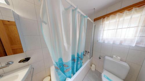 a bathroom with a toilet and a shower curtain at Triantha TR0 in Blatten bei Naters