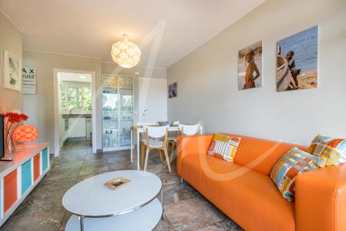 a living room with an orange couch and a table at Estrella by SeaMount Rentals in Calella de Palafrugell