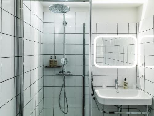 a white tiled bathroom with a shower and a sink at Le Relais de Saint de Ser in Puyloubier