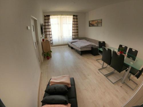ein Wohnzimmer mit einem Bett, einem Tisch und Stühlen in der Unterkunft Apartmán Znojmo in Znojmo