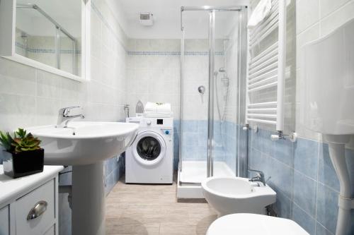 a bathroom with a sink and a washing machine at Butterfly Apartment in Rapallo