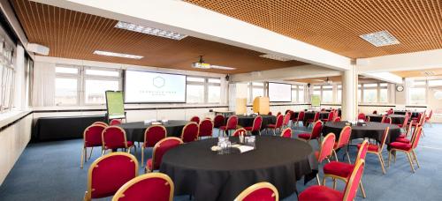 a conference room with tables and chairs and a screen at Yarnfield Park Training And Conference Centre in Stone