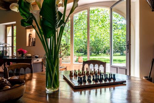 a vase with a chess board on a table at Gîtes Domaine des Machottes in Grans