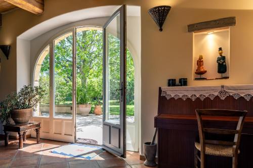 an arched entryway with a door leading to a patio at Gîtes Domaine des Machottes in Grans