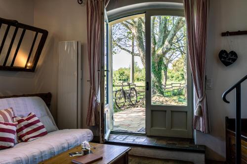 a living room with a couch and a sliding glass door at Gîtes Domaine des Machottes in Grans