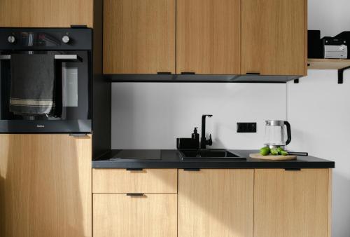a kitchen with a black microwave and a sink at Aparthotel Narciarska 2 in Korbielów