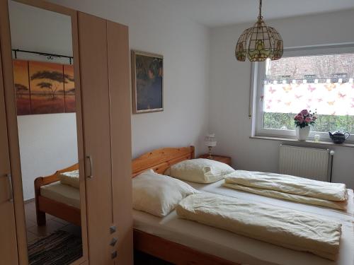 - une chambre avec deux lits, une fenêtre et un lustre dans l'établissement Nicoles Niedschlösschen, à Rehlingen-Siersburg