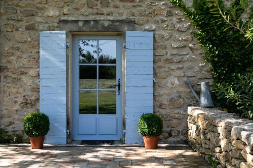 a blue door of a stone house with two plants at Gîtes Domaine des Machottes in Grans