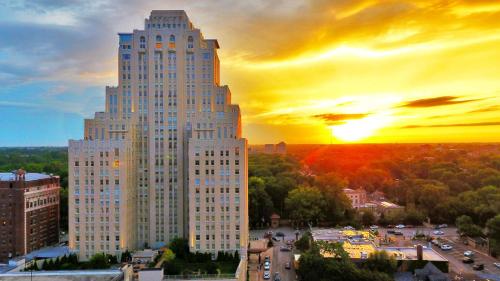 a tall white building with the sunset in the background at The Royal Sonesta Chase Park Plaza St Louis in Saint Louis
