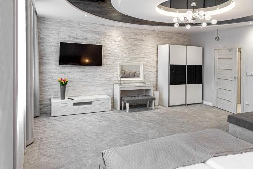 a bedroom with a tv on a brick wall at Kamienica Pod Neptunem in Puck