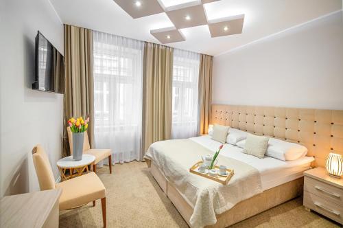 a hotel room with a bed and a chair and a table at Kamienica Pod Neptunem in Puck