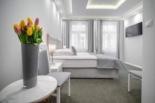 a bedroom with a bed and a vase of flowers on a table at Kamienica Pod Neptunem in Puck