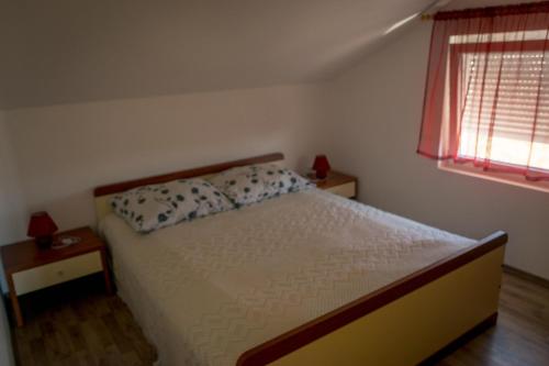 a bedroom with a bed and a window at Apartment Elza in Povljana