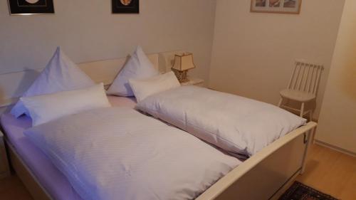 two beds with white pillows sitting next to each other at Ferienwohnung Neckarblick in Heidelberg