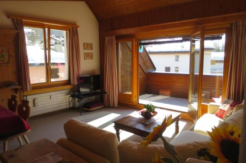 uma sala de estar com um sofá e uma mesa em Chesa Rosatsch em Surlej
