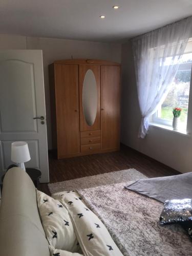 a bedroom with a couch and a dresser and a window at Isabela Apartments in Palanga