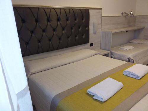 a bedroom with two beds with white towels on them at Hotel Playa in Viareggio