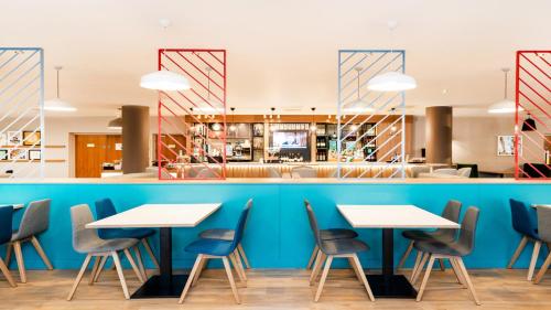 a row of tables and chairs in a restaurant at Holiday Inn London Luton Airport by IHG in Luton
