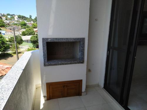 a fireplace on the side of a white wall at Apto próximo Centro Eventos in Chapecó
