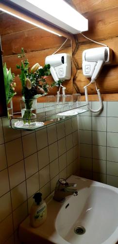 a bathroom with a sink and a light on the wall at Urpolan Kartano Ky in Humppila