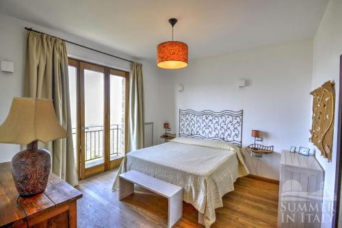 1 dormitorio con 1 cama con mesa y lámpara en Sulle Onde Della Collina, en Montecorice