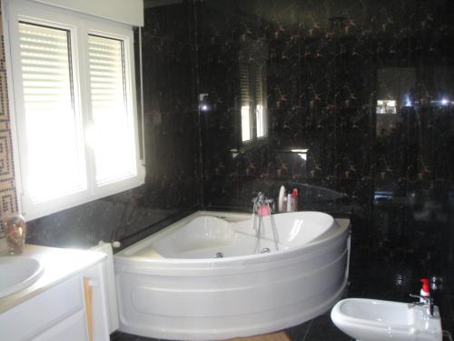 a bathroom with a tub and a sink and a toilet at CHALET MUY CERCA DE LA PLAYA CON PISCINA PRIVADA in Orihuela Costa