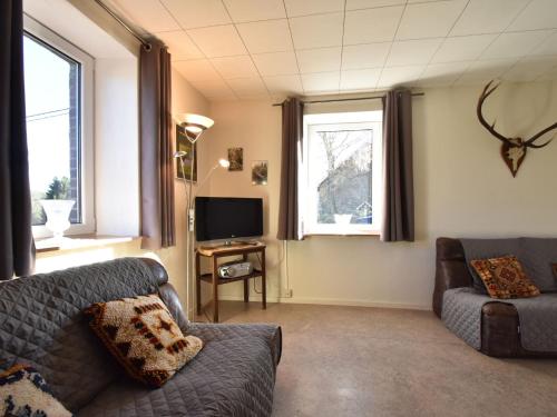 - un salon avec un canapé et une télévision dans l'établissement Quaint Cottage in Kuchelscheid with Terrace, à Küchelscheid