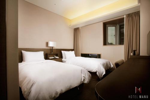 a hotel room with two beds and a window at Hotel Manu Seoul in Seoul