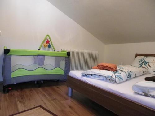 a bedroom with two beds with a baby crib at Landhaus Daum in Schwendau
