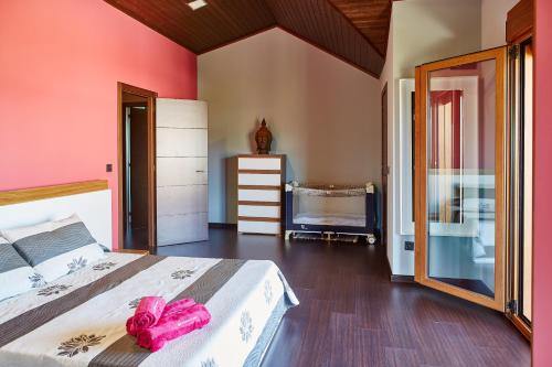 Un dormitorio con una cama con toallas rosas. en Gándara Chalet, en Salvatierra de Miño